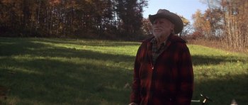 Movie still from “The Straight Story” (1999), directed by David Lynch – An older man in a cowboy hat standing in a field; Medium shot, Low angle