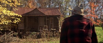 Movie still from “The Straight Story” (1999), directed by David Lynch – An older man standing in front of an old house; Wide shot, Over the shoulder angle