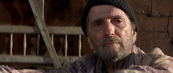 Movie still from “The Straight Story” (1999), directed by David Lynch – An old man with a beard wearing a black hat; Close Up shot, Over the shoulder angle