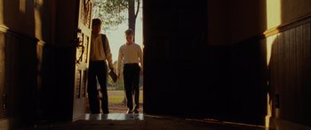 Movie still from “The Strangers” (2008), directed by Bryan Bertino – Two men are walking down the sidewalk of a building; Wide shot, Low angle