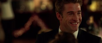 Movie still from “The Strangers” (2008), directed by Bryan Bertino – A person wearing a suit and smiling; Close Up shot, Over the shoulder angle