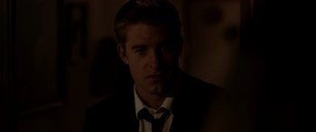 Movie still from “The Strangers” (2008), directed by Bryan Bertino – A person wearing a suit and tie; Close Up shot, Over the shoulder angle