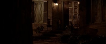 Movie still from “The Strangers” (2008), directed by Bryan Bertino – A porch lit up at night by a lamp; Extreme Wide shot, High angle