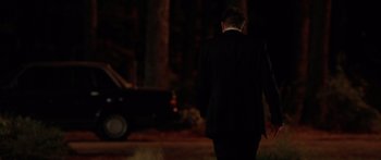 Movie still from “The Strangers” (2008), directed by Bryan Bertino – A man in a suit walking down a street at night; Wide shot, Over the shoulder angle