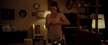 Movie still from “The Strangers” (2008), directed by Bryan Bertino – A woman in a nightgown standing in front of a table; Medium shot, Over the shoulder angle