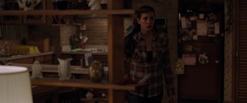 Movie still from “The Strangers” (2008), directed by Bryan Bertino – A woman standing in front of a shelf in a room; Medium shot, Over the shoulder angle