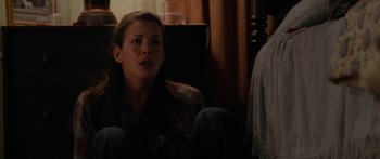 Movie still from “The Strangers” (2008), directed by Bryan Bertino – A woman sitting on a couch in a living room; Medium shot, High angle