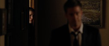 Movie still from “The Strangers” (2008), directed by Bryan Bertino – A man in a suit and tie standing next to a woman in a dress; Medium shot, Over the shoulder angle