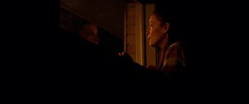 Movie still from “The Strangers” (2008), directed by Bryan Bertino – A woman looking in a mirror while talking to another woman; Medium shot, Over the shoulder angle