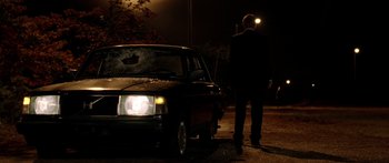 Movie still from “The Strangers” (2008), directed by Bryan Bertino – A man standing in front of a car at night; Wide shot, Low angle