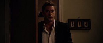 Movie still from “The Strangers” (2008), directed by Bryan Bertino – A person wearing a suit and tie; Medium shot, Over the shoulder angle