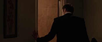 Movie still from “The Strangers” (2008), directed by Bryan Bertino – A man in a suit is opening a door; Medium shot, Over the shoulder angle