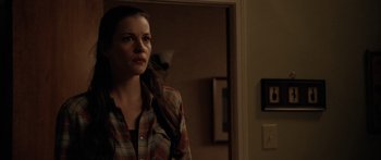 Movie still from “The Strangers” (2008), directed by Bryan Bertino – A woman standing in front of an open door; Medium shot, Over the shoulder angle