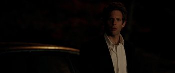 Movie still from “The Strangers” (2008), directed by Bryan Bertino – A man wearing a suit and tie standing in front of a car; Close Up shot, Over the shoulder angle