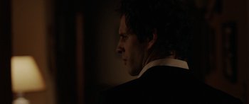 Movie still from “The Strangers” (2008), directed by Bryan Bertino – A person wearing a suit and tie; Close Up shot, Over the shoulder angle