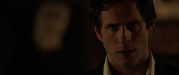 Movie still from “The Strangers” (2008), directed by Bryan Bertino – A person wearing a suit and tie; Close Up shot, Over the shoulder angle