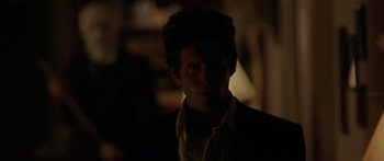 Movie still from “The Strangers” (2008), directed by Bryan Bertino – A man in a dark room with his head turned to the side; Close Up shot, Over the shoulder angle