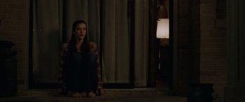 Movie still from “The Strangers” (2008), directed by Bryan Bertino – A woman sitting on the ground in front of a window; Wide shot, Over the shoulder angle