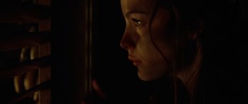Movie still from “The Strangers” (2008), directed by Bryan Bertino – A woman looking into the distance in the dark; Close Up shot, Over the shoulder angle