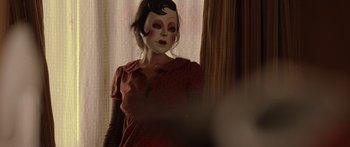 Movie still from “The Strangers” (2008), directed by Bryan Bertino – A woman in a red dress with makeup on her face; Close Up shot, Low angle