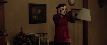 Movie still from “The Strangers” (2008), directed by Bryan Bertino – A woman in a red dress holding her hands to her face; Medium shot, Over the shoulder angle