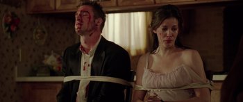 Movie still from “The Strangers” (2008), directed by Bryan Bertino – A man and a woman tied to a chair; Medium shot, Low angle