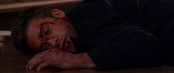 Movie still from “The Strangers” (2008), directed by Bryan Bertino – A man laying on the ground with blood all over his face; Close Up shot, Overhead angle