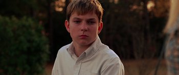 Movie still from “The Strangers” (2008), directed by Bryan Bertino – A young man in a white dress shirt is looking at the camera; Close Up shot, Low angle