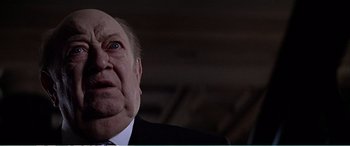 Movie still from “The Sum of All Fears” (2002), directed by Phil Alden Robinson – An older man in a suit and tie looking up; Close Up shot, Low angle