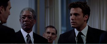Movie still from “The Sum of All Fears” (2002), directed by Phil Alden Robinson – A man in a suit and tie standing next to another man in a suit and tie; Close Up shot, Low angle