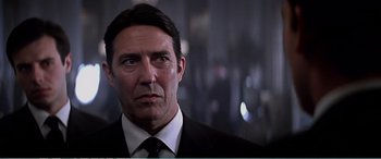 Movie still from “The Sum of All Fears” (2002), directed by Phil Alden Robinson – A person wearing a suit and tie; Close Up shot, Low angle