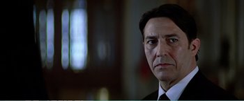 Movie still from “The Sum of All Fears” (2002), directed by Phil Alden Robinson – A person wearing a suit and tie; Close Up shot, Low angle