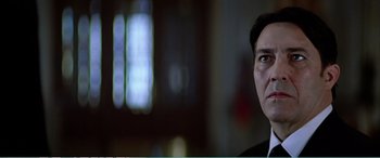 Movie still from “The Sum of All Fears” (2002), directed by Phil Alden Robinson – A person wearing a suit and tie; Close Up shot, Low angle