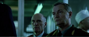 Movie still from “The Sum of All Fears” (2002), directed by Phil Alden Robinson – Two men in suits and ties looking at the camera; Close Up shot, Low angle