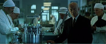 Movie still from “The Sum of All Fears” (2002), directed by Phil Alden Robinson – A man standing in front of a machine in a room; Medium shot, Low angle