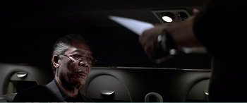 Movie still from “The Sum of All Fears” (2002), directed by Phil Alden Robinson – A man in a car holding a knife in his hand; Close Up shot, Over the shoulder angle