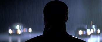 Movie still from “The Sum of All Fears” (2002), directed by Phil Alden Robinson – A man standing in front of a street light in the dark; Close Up shot, Low angle
