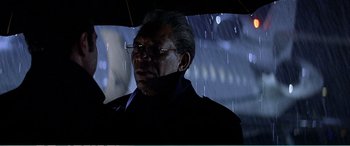 Movie still from “The Sum of All Fears” (2002), directed by Phil Alden Robinson – An older man holding an umbrella in the rain at night; Close Up shot, Low angle