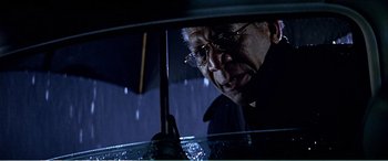 Movie still from “The Sum of All Fears” (2002), directed by Phil Alden Robinson – An older man holding an umbrella in the rain; Close Up shot, Low angle
