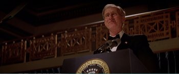 Movie still from “The Sum of All Fears” (2002), directed by Phil Alden Robinson – An older man in a tuxedo is speaking at a political event; Close Up shot, Low angle
