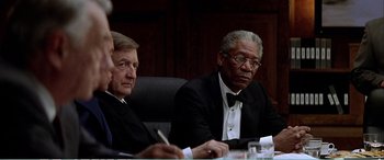 Movie still from “The Sum of All Fears” (2002), directed by Phil Alden Robinson – Two men in suits sitting at a conference table; Medium shot, Over the shoulder angle