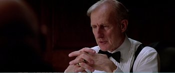 Movie still from “The Sum of All Fears” (2002), directed by Phil Alden Robinson – An older man wearing a white shirt and a black bow tie; Close Up shot, Low angle