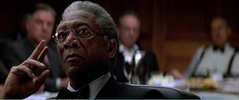 Movie still from “The Sum of All Fears” (2002), directed by Phil Alden Robinson – An older man wearing a suit and tie in front of another man in a suit and tie; Close Up shot, Low angle