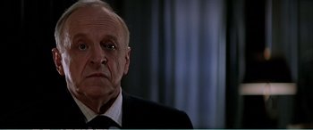 Movie still from “The Sum of All Fears” (2002), directed by Phil Alden Robinson – An older man in a suit and tie looking sad; Close Up shot, Low angle