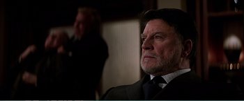 Movie still from “The Sum of All Fears” (2002), directed by Phil Alden Robinson – An older man wearing a suit and tie; Close Up shot, Over the shoulder angle