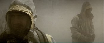 Movie still from “The Sum of All Fears” (2002), directed by Phil Alden Robinson – A person in a gas mask is holding a hose in front of a wall; Extreme Close Up shot, Low angle