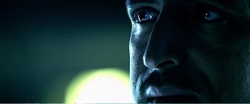 Movie still from “The Sum of All Fears” (2002), directed by Phil Alden Robinson – A man's face in a dimly - lit room; Extreme Close Up shot, Low angle