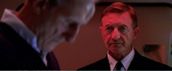 Movie still from “The Sum of All Fears” (2002), directed by Phil Alden Robinson – A man wearing a suit and tie looking at another man in a suit and tie; Close Up shot, Over the shoulder angle