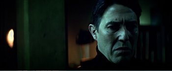 Movie still from “The Sum of All Fears” (2002), directed by Phil Alden Robinson – A person's face in a dark room; Close Up shot, Low angle