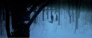 Movie still from “The Sum of All Fears” (2002), directed by Phil Alden Robinson – A group of people standing in the snow near a forest; Extreme Wide shot, High angle